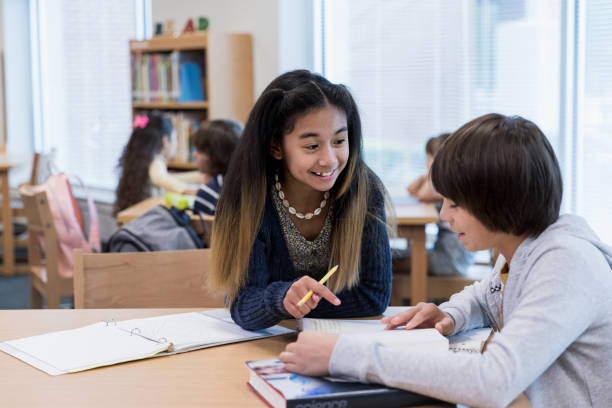 istock Middle school boy and girl discuss textbook reading 1193583389