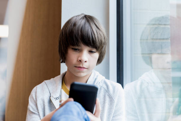istock Serious middle school boy searches internet on phone 1193583422