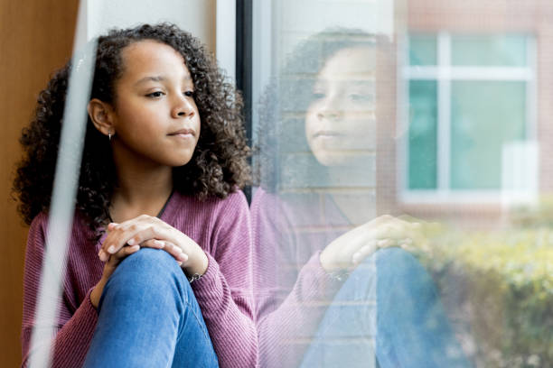 Middle school girl takes break from studying to relax Taking a break from studying to relax, the middle school girl looks out the window. critical thinking kids stock pictures, royalty-free photos & images