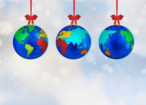 istock 3D illustration of Christmas ornament globe bulb decorations with world maps, each hanging from a red ribbon against a falling snow background. Clipping path for the three bulbs 1193584489
