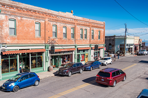 Cars drive past store facades in downtown Jerome Arizona USA on a sunny day