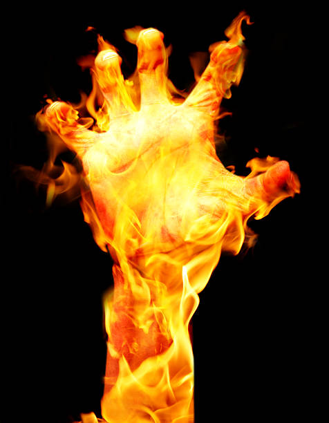 Arm and hand on fire with black background.