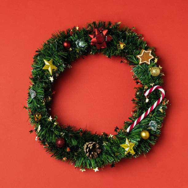 istock Christmas creative concept flat lay, christmas wreath from green tinsel with gingerbread cookie, candy cane, pinecone, stars, bow 1193602032