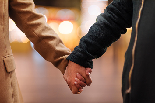Close up photo of an elderly couple holding hands