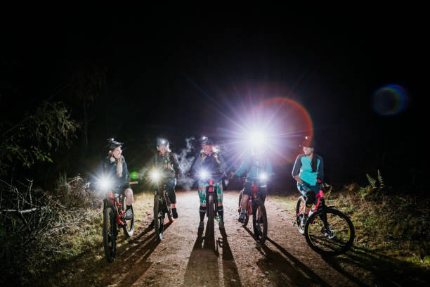 Women's Mountain Biking Club on Night Ride An all female mountain bike team enjoys a ride on some forest trails at night, equipped with bright head lamps and bike lights.   Shot in Washington State on the Olympic Peninsula. bicycle light photos stock pictures, royalty-free photos & images