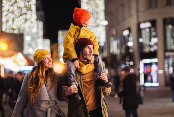 istock Father carrying kid on shoulders and mother standing beside 1193602636