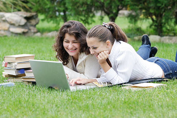 istock two student girls with laptop on natural background 119361038