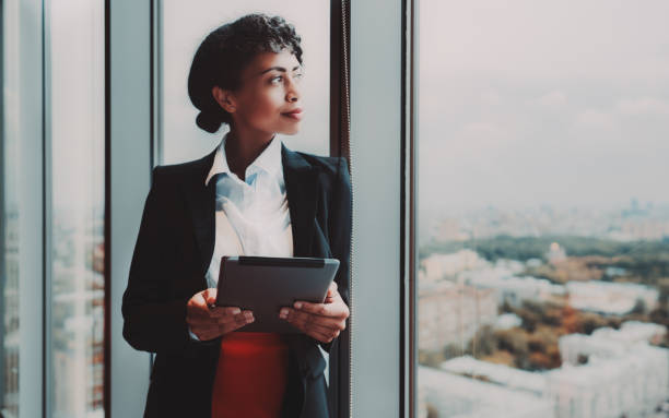 mulher de negócios biracial e pc da tabuleta - thinking women businesswoman business person - fotografias e filmes do acervo