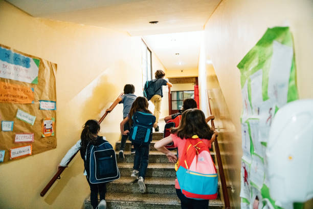 gruppe der grundschüler, die in den unterricht gehen - schulgebäude stock-fotos und bilder