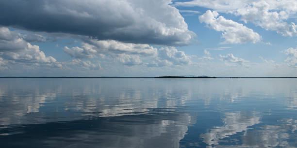 istock Nephology art. A beautiful sky cloudscape scene, with white Cumulus cloud in a mid blue sky over ocean. 1193612255