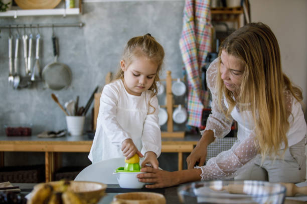 istock Little girl making a lemonade with her mother 1193614179