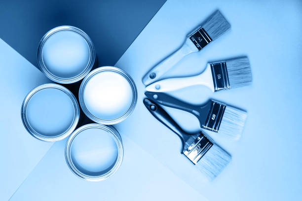 istock Four open cans of paint with brushes on bright background. 1193627261