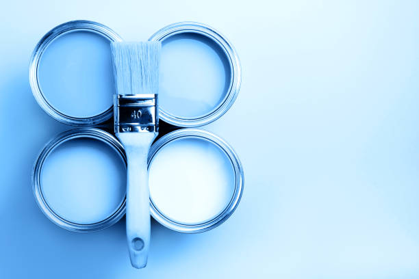 istock Four open cans of paint with brushes on bright background. 1193627263