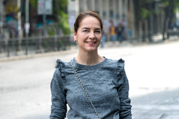 portrait of a mature woman 45 - 50 years smiling looking camera over an urban - city background - 45 50 years portrait mature women one mature woman only imagens e fotografias de stock