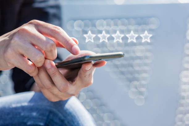 Customer Service Experience Performance Analysis. Close-up of Woman's Hand Holding a Smart Phone with Icon Five Star Symbol to Increase Rating of Company Customer Service Experience Performance Analysis. Close-up of Woman's Hand Holding a Smart Phone with Icon Five Star Symbol to Increase Rating of Company. rating stock pictures, royalty-free photos & images