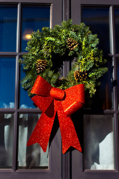 istock Green Christmas Wreath, Pinecones, Red Bow on Window 1193632372