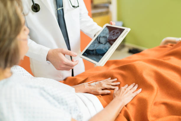 istock Healthcare Worker Explaining X-ray On Wireless Computer In Hospital 1193636878