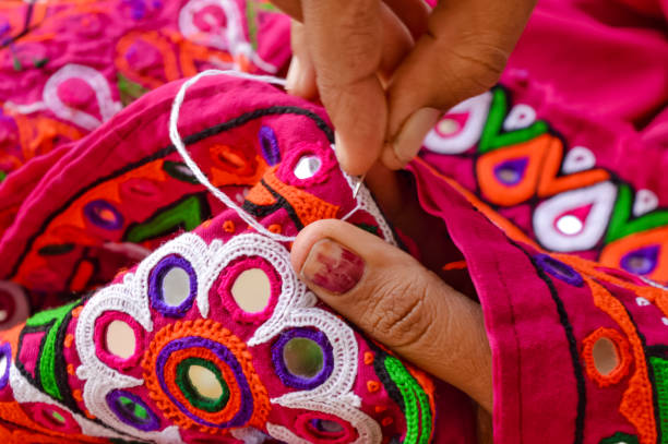 female needlework on fabric material close up view,unidentified tribal women sewing ethnic dresses,ahir embroidery art work close up view,gujarat india embroidery - traditional culture asia indigenous culture india imagens e fotografias de stock