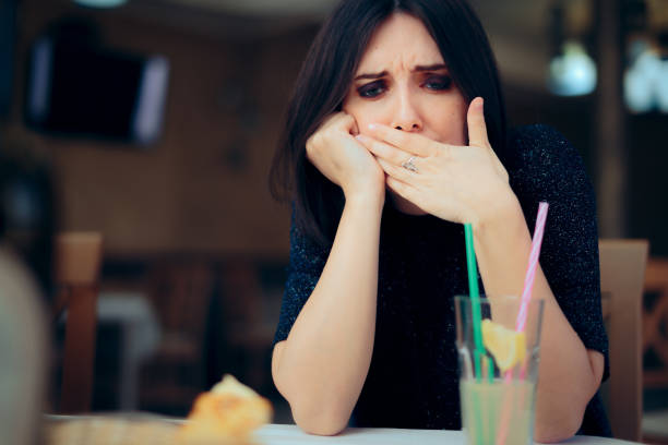 donna nauseata che si sente male al ristorante - usare la bocca foto e immagini stock