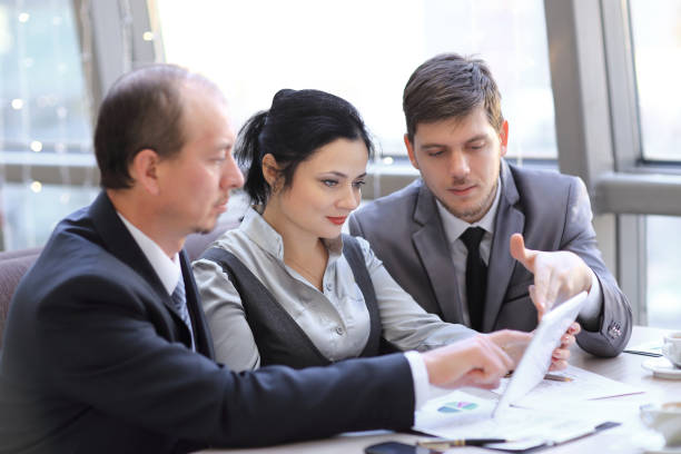 istock close up.business team discussing financial charts using digital tablet. 1193653337