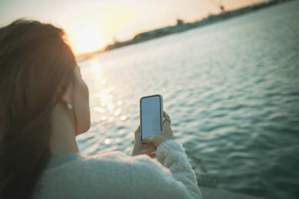 istock Asian woman using smartphone in the park 1193654815