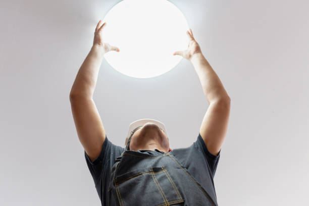 istock Electrician with white helmet checking lighting to the ceiling in the home, technician concept. 1193658760