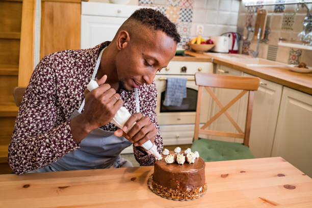istock Brazilian man decorating a cake at home 1193662998
