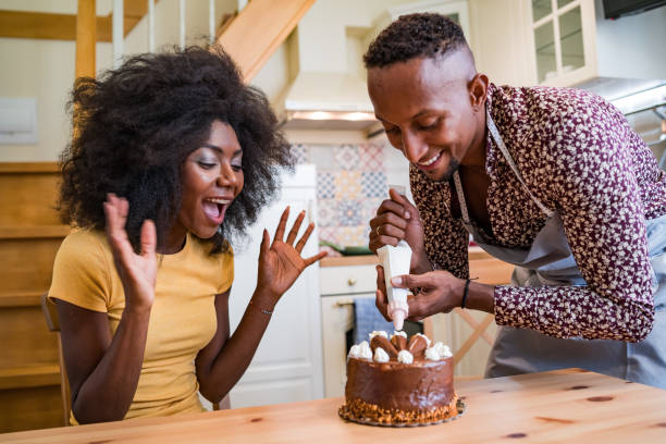 istock Couple in love decorating a cake at home 1193663022