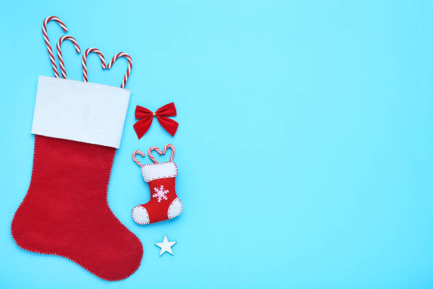 istock Red stocking with christmas ornaments and candy canes on blue background 1193666577