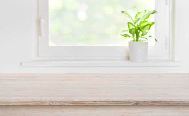 istock Natural texture wooden tabletop with blurred window for product display 1193666864