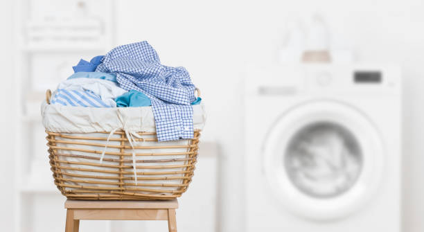 wäschekorb auf verschwommenem hintergrund moderner waschmaschine - wäsche fotos stock-fotos und bilder