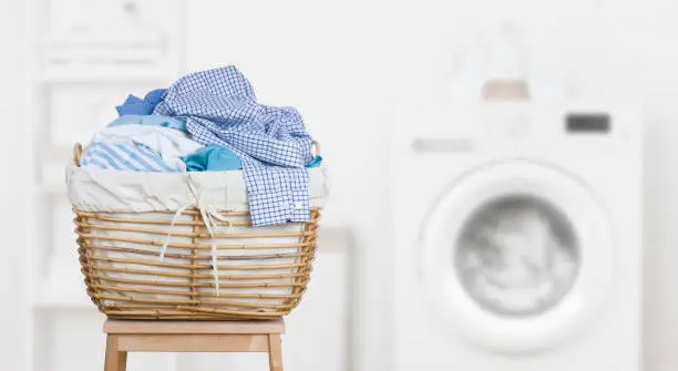 Laundry basket on blurred background of modern washing machine