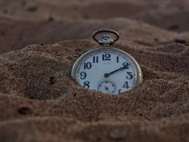 istock vintage pocket watch on sand closeup.soft focus 1193666961