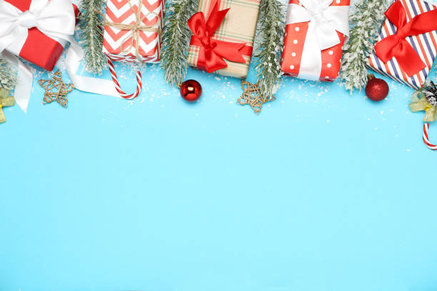 istock Gift boxes with christmas ornaments and fir tree branches on blue background 1193667707