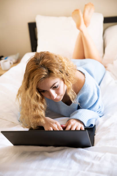 青いセーターを着た女性 - furniture internet adult blond hair ストックフォトと画像