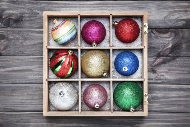 istock Colorful christmas baubles in box on wooden table 1193669014