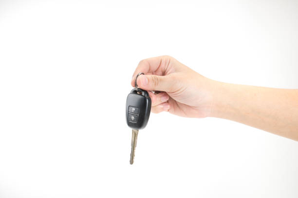 istock A hand holding a car key on a white background. 1193672544