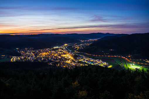 Germany, Houses of city haslach im kinzigtal in black forest, streets and cityscape illuminated by night, aerial view from above with red sky