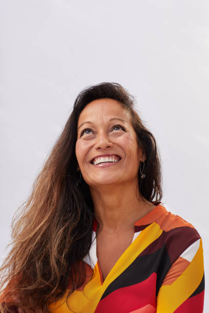 istock Smiling mature woman looking up at copyspace on a gray background 1193677238