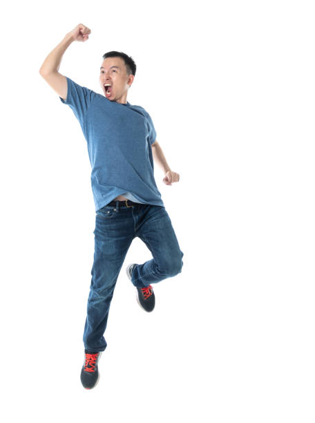 hombre emocionado saltando sobre fondo blanco - cheering men t shirt celebration fotografías e imágenes de stock
