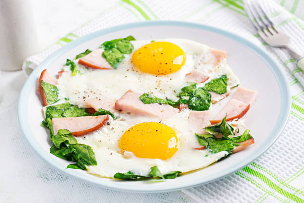 jajka sadzone z szynką i szpinakiem. pyszne śniadanie angielskie. brunch. dieta keto/paleo. - spinach salad fork low carb diet zdjęcia i obrazy z banku zdjęć