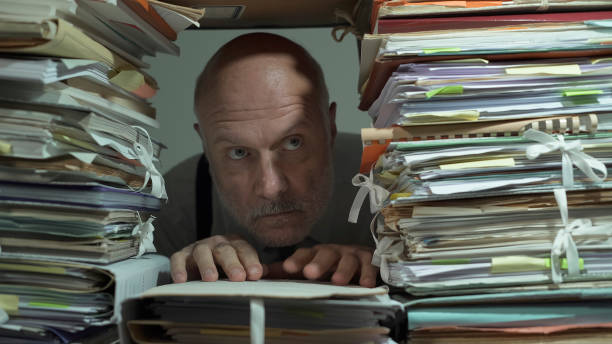 istock Creepy office clerk overloaded with paperwork 1193687383