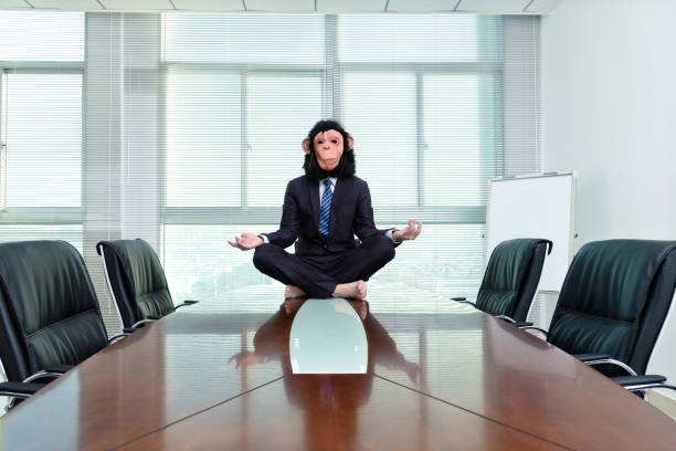 istock Businessman wearing a mask meditating on conference table 1193688596