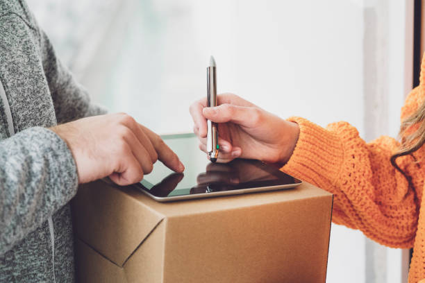 istock Woman hand signing on digital tablet after receiving a parcel 1193688633