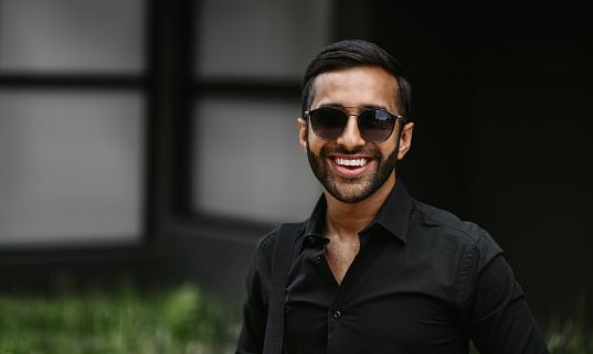 Portrait Of A Smiling Stylish Young Indian Arabic Guy Wearing Sunglasses  And Black Shirt Stock Photo - Download Image Now - iStock