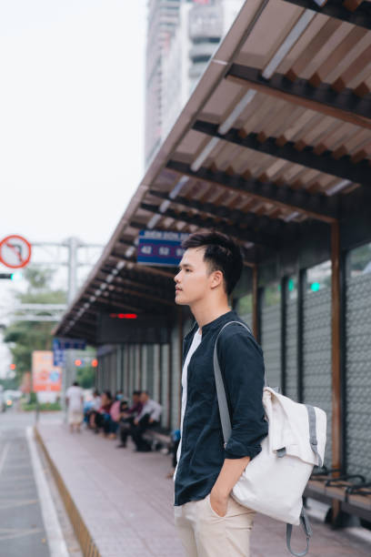 istock Young man standing at the bus stop waiting for the bus 1193692700