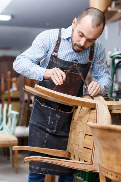 istock Carpenter repairing antique chair 1193695751