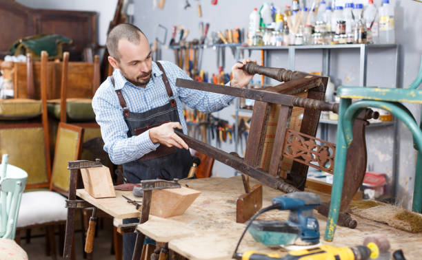 istock Artisan inspecting old chair 1193695774