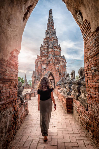 jeune femme explorant le temple de wat chai watthanaram à ayutthaya, thaïlande - ayuthaya photos et images de collection