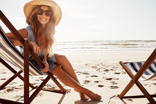 Portrait of a young woman relaxing on a lounger at the beach